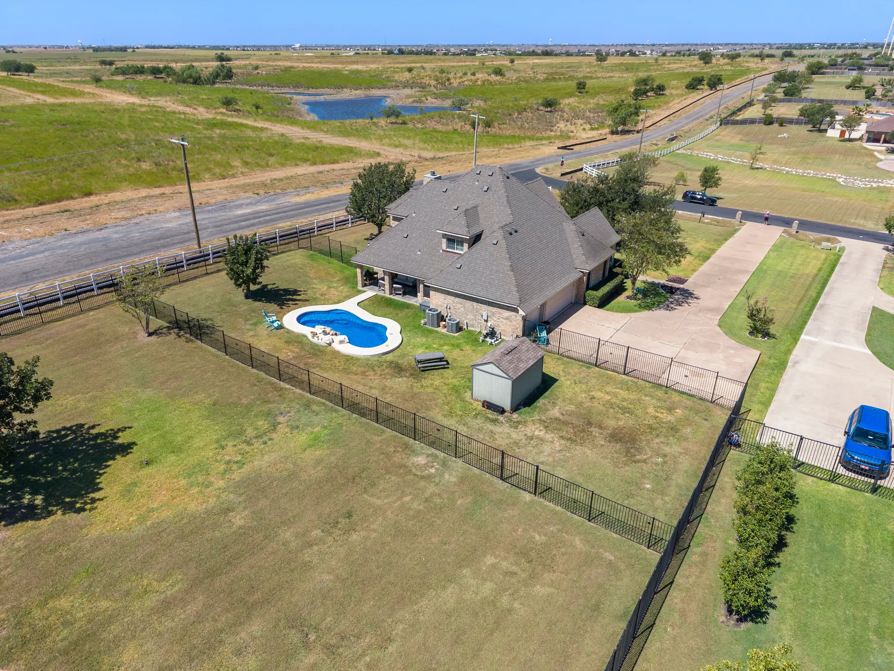 Rear aerial view across the pool and acreage