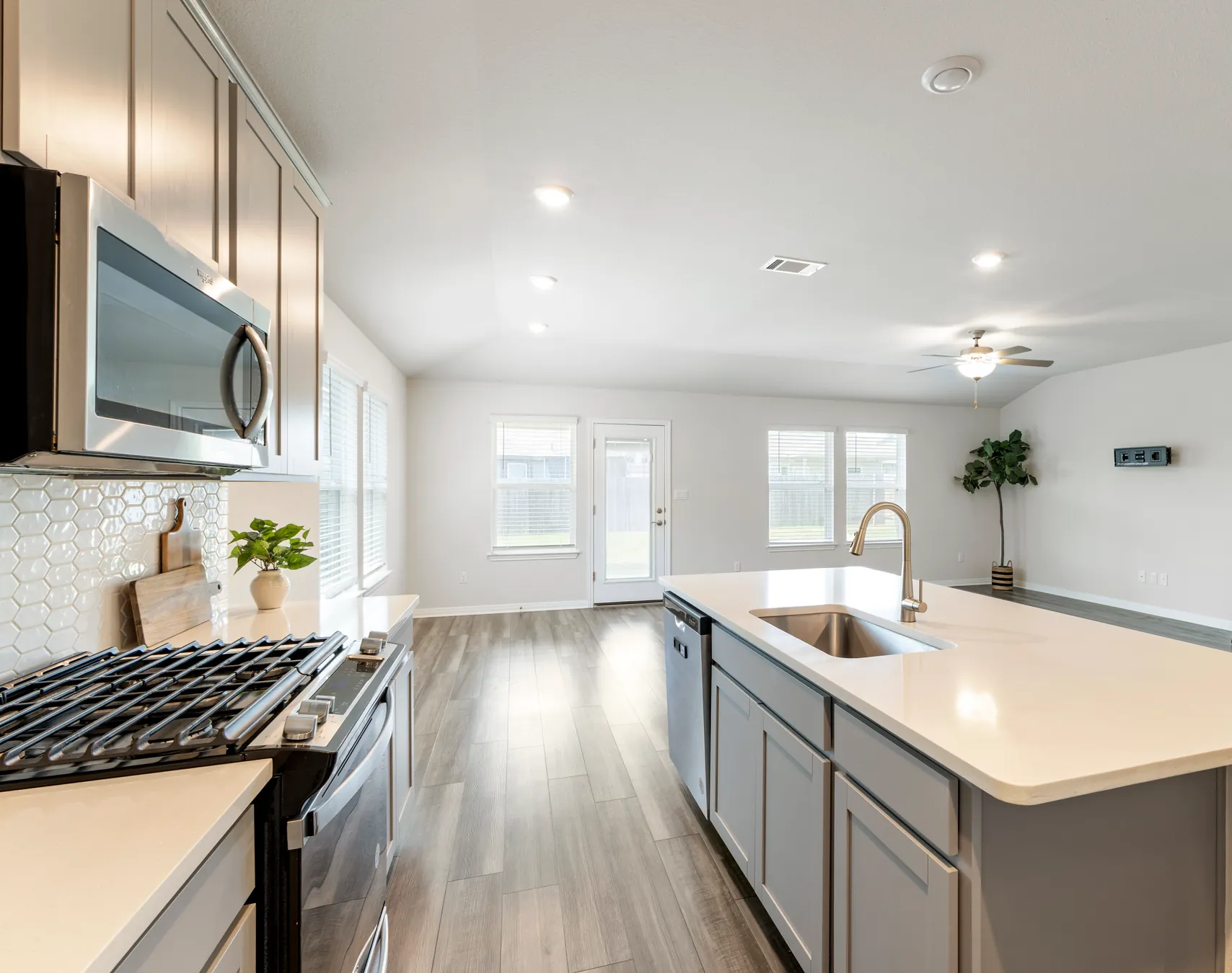 Open kitchen and living area with grey cabinetry